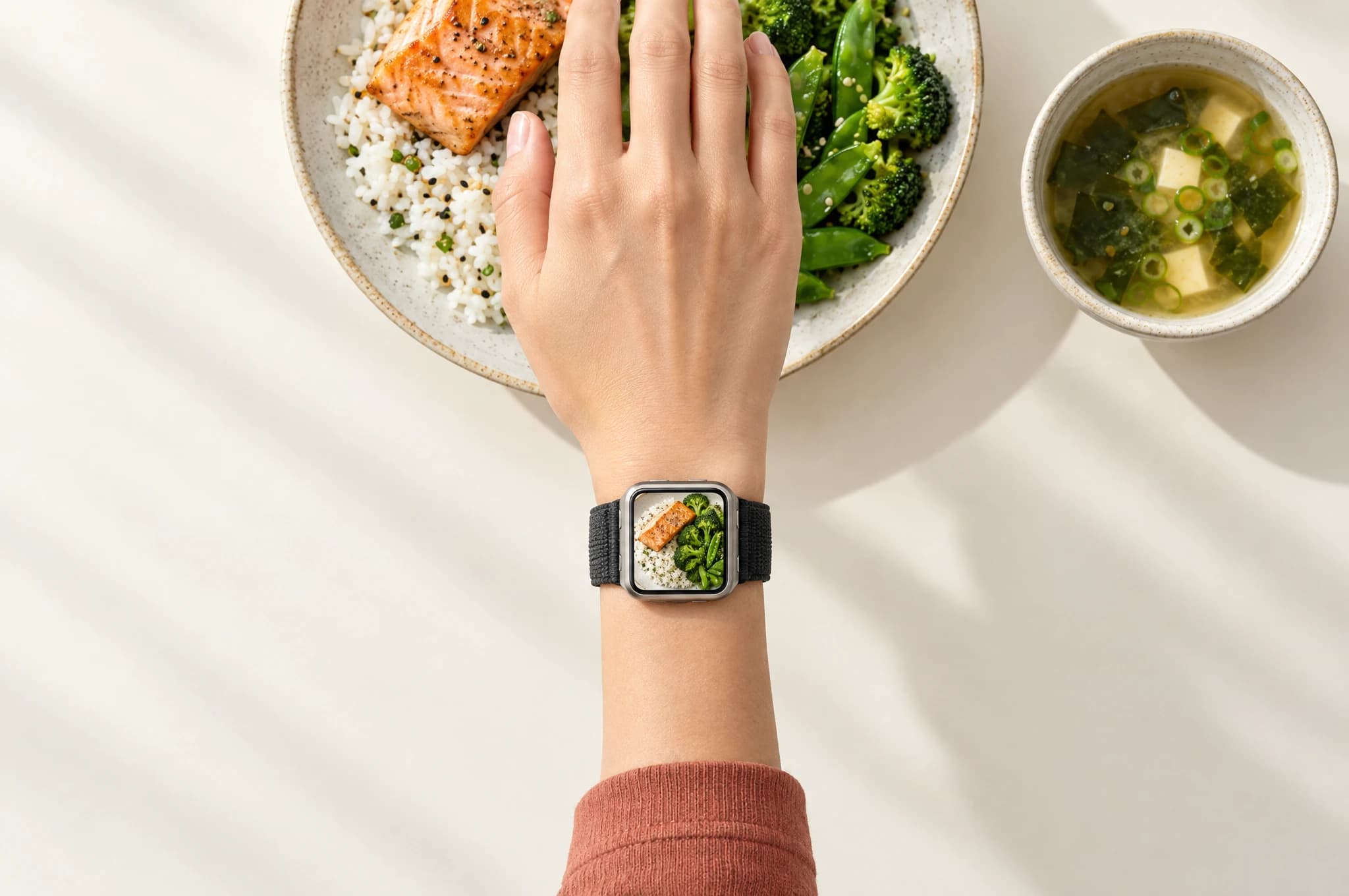 Overhead view of a right wrist above lunch, with the meal shown on the watch screen